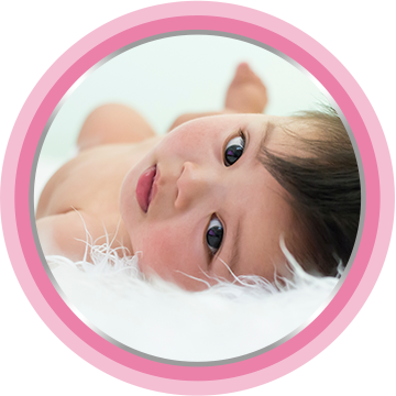 Baby laying on bed with a toy